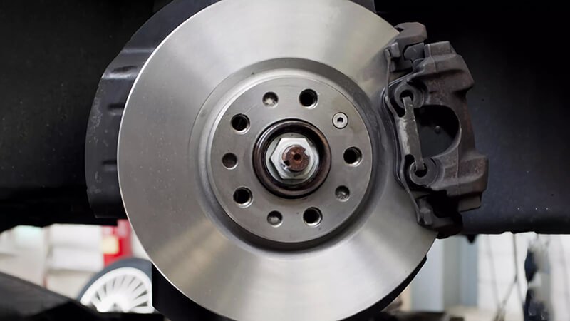 Brake disc and caliper close-up, highlighting metallic precision and assembly