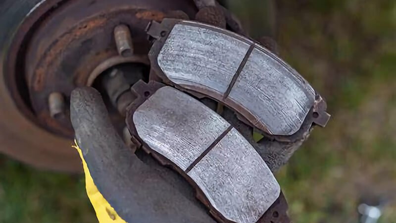 Worn-out brake pads being replaced, emphasizing the importance of timely maintenance