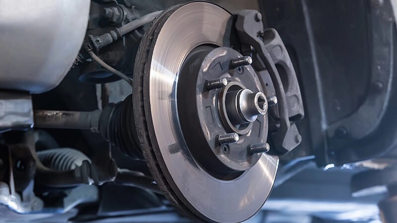 Technician carefully installing brake pads on a heavy-duty vehicle axle