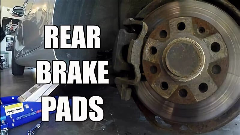 Replacing rear brake pads, showing installation process at a repair shop