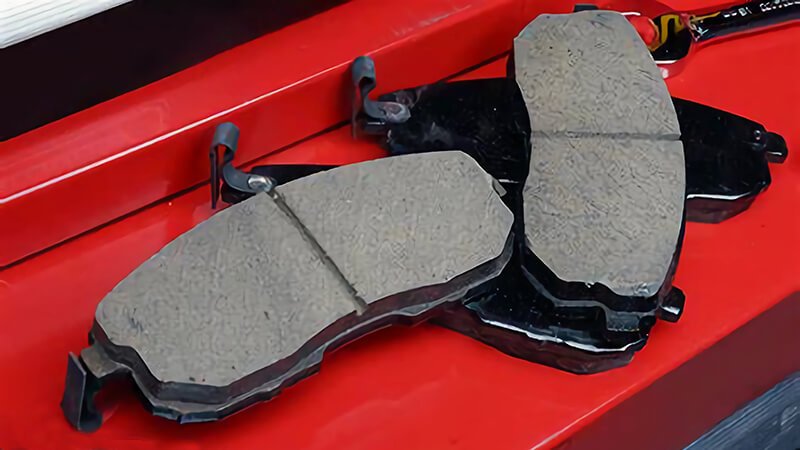 New brake pads on red workbench